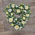 A 15 inch classic open heart-shaped wreath in White flowers and green leaves
