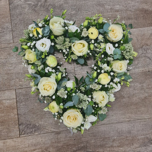 A 15 inch classic open heart-shaped wreath in White flowers and green leaves