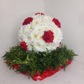 A 3D football made of white and red flowers, resting on a greenery base.