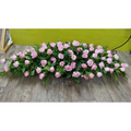 A large coffin spray arrangement with roses and dark green foliage.