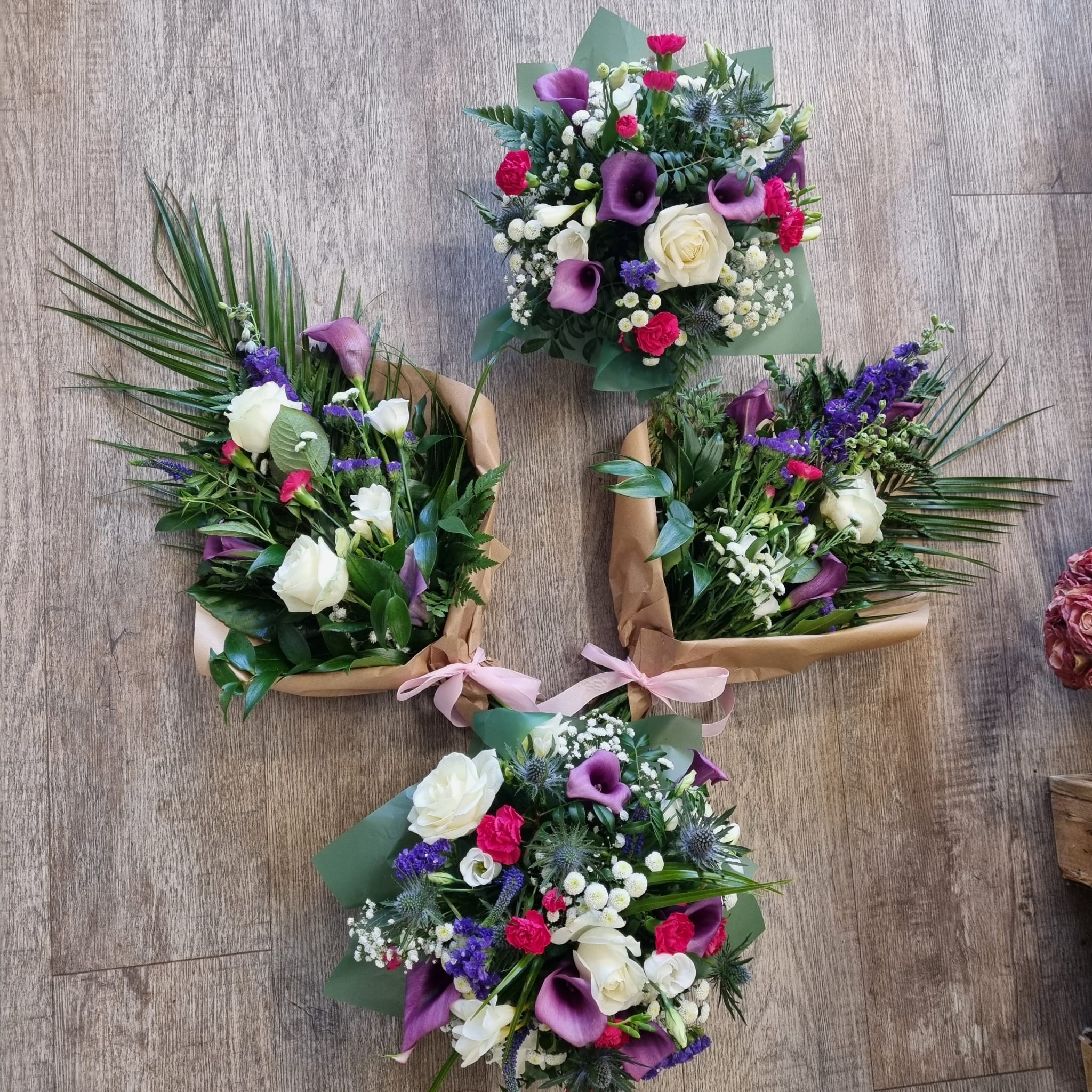 Four floral arrangements (two bouquets and two posies) featuring a mix of flowers from the casket spray you ordered.
