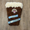 A decorative John Smith's pint glass made of flowers, with a label on top and personalized text 'Dad Grandad' on the front.
