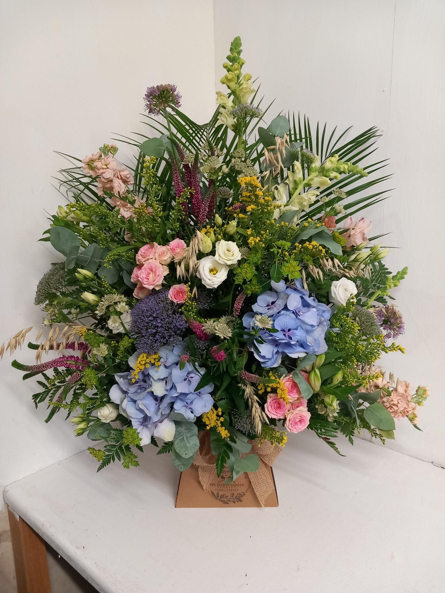 A WOW-sized box arrangement featuring a variety of natural-looking flowers in a mix of colors, arranged in a natural style.