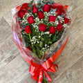 A rose bouquet consisting of large-headed roses with foliage and gypsophila, wrapped in cellophane and tied with a ribbon.
