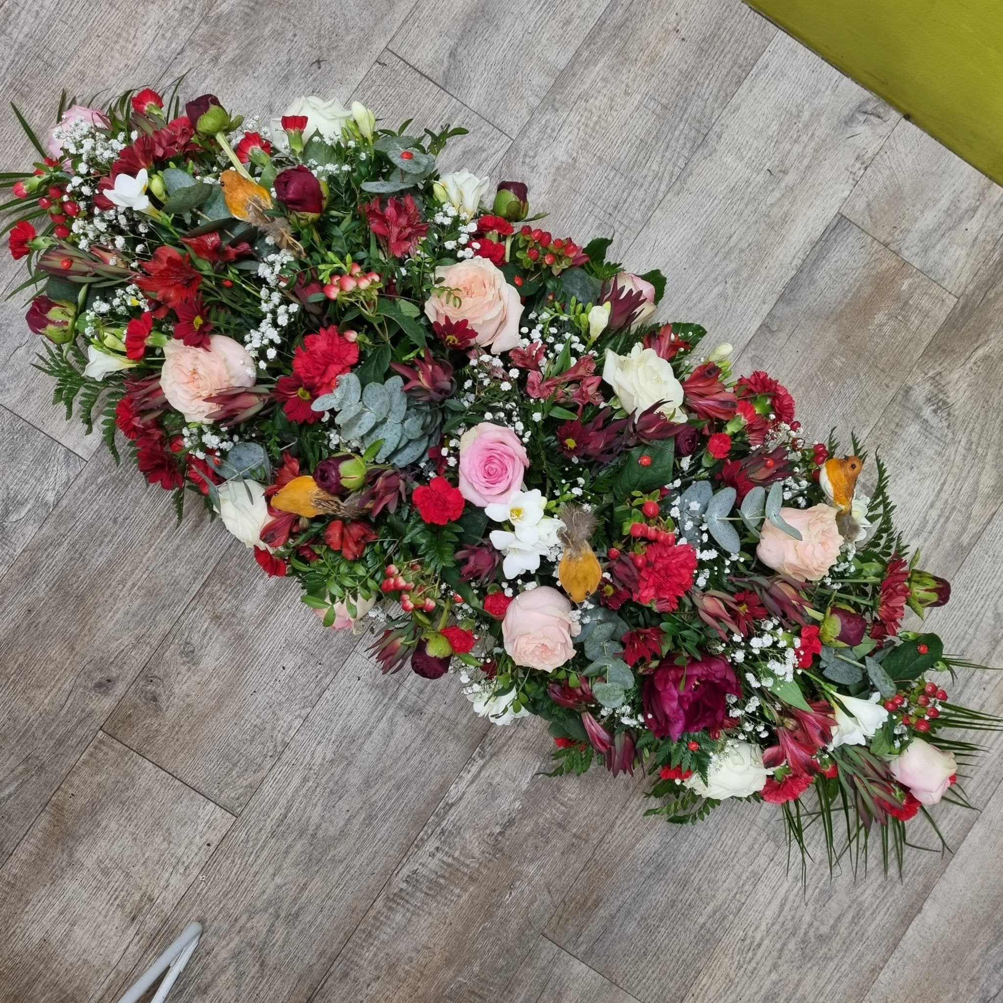 A 4ft double-ended coffin spray with a mix of red, peach, pink, and white flowers