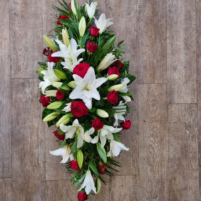 A floral arrangement featuring white lilies and roses