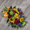 A brightly colored tied sheaf of flowers including sunflowers and various other flowers