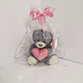 Plush toy with pink heart and bow in clear packaging