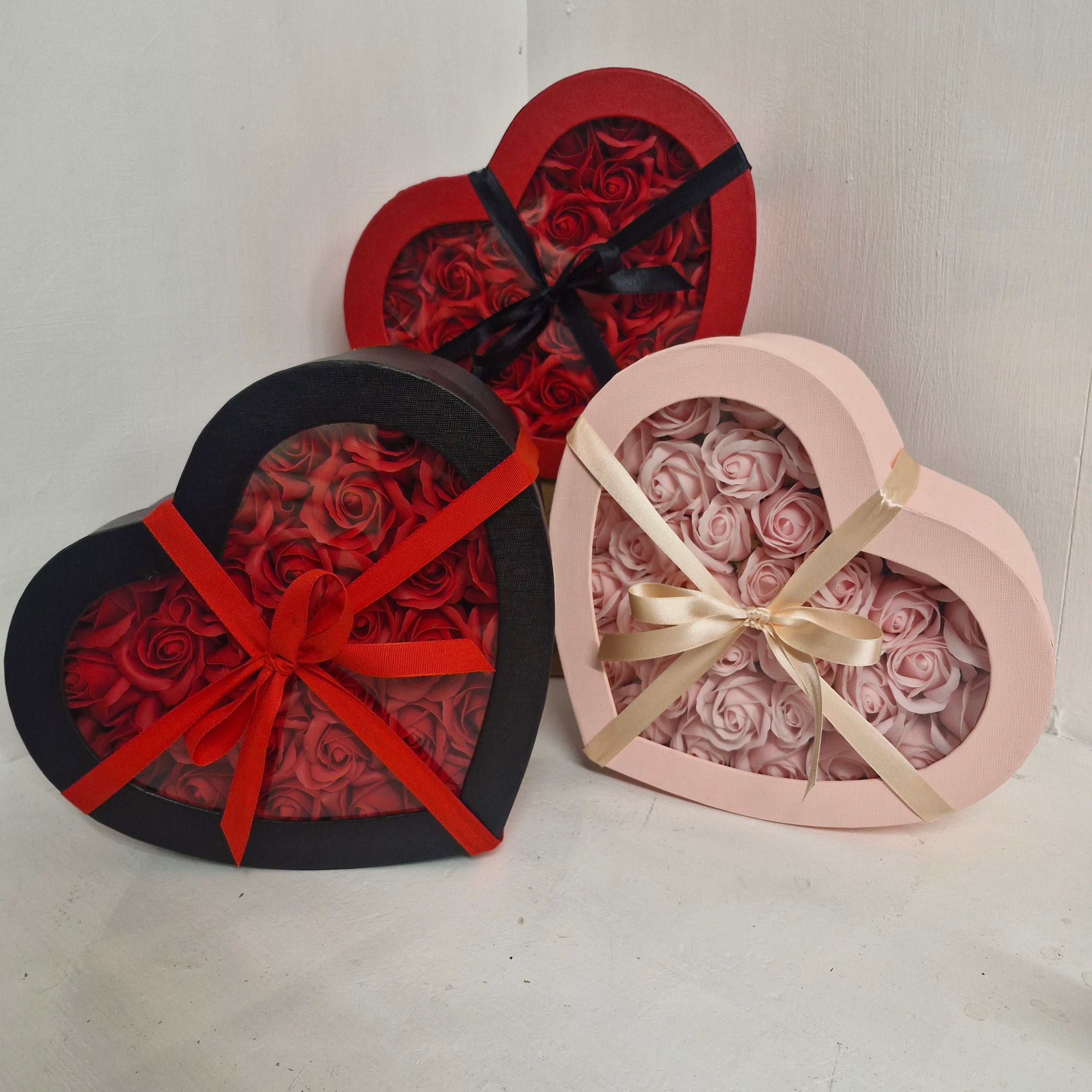 Heart-shaped boxes roses on a light gray background