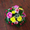 A seasonal round floral posy with pink, yellow, and white flowers. Colours can be changed