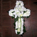 A white massed cross with lily spray