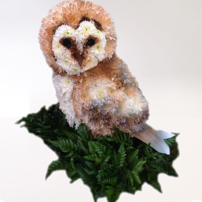 A 3D model of an owl sitting on a green square base, with a realistic design including feather details