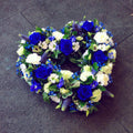 A 15 inch open heart-shaped wreath arrangement with a combination of blue and white flowers